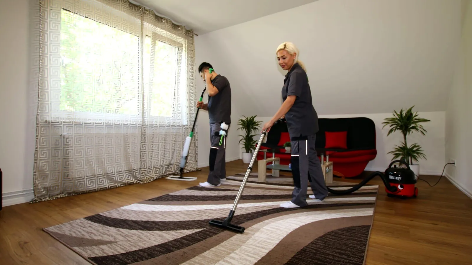 Haushaltshilfe: Zwei Mitarbeitende reinigen ein Wohnzimmer mit Teppich