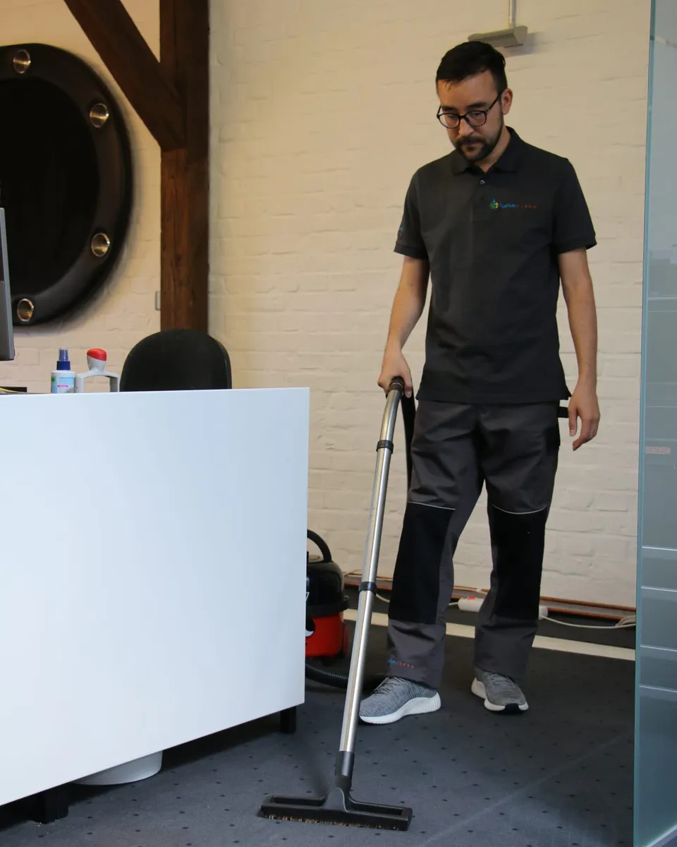 Barbat-Clean-Mitarbeiter saugt den Bereich vor einem Büroempfang