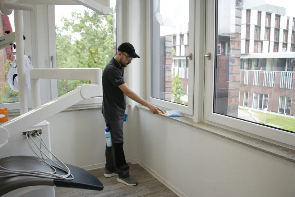 Barbat-Clean-Mitarbeiter reinigt die Fensterbank in einem Behandlungsraum