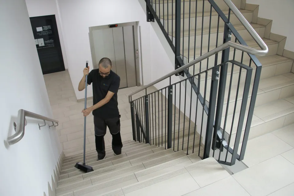 Barbat-Clean-Mitarbeiter fegt ein Treppenhaus